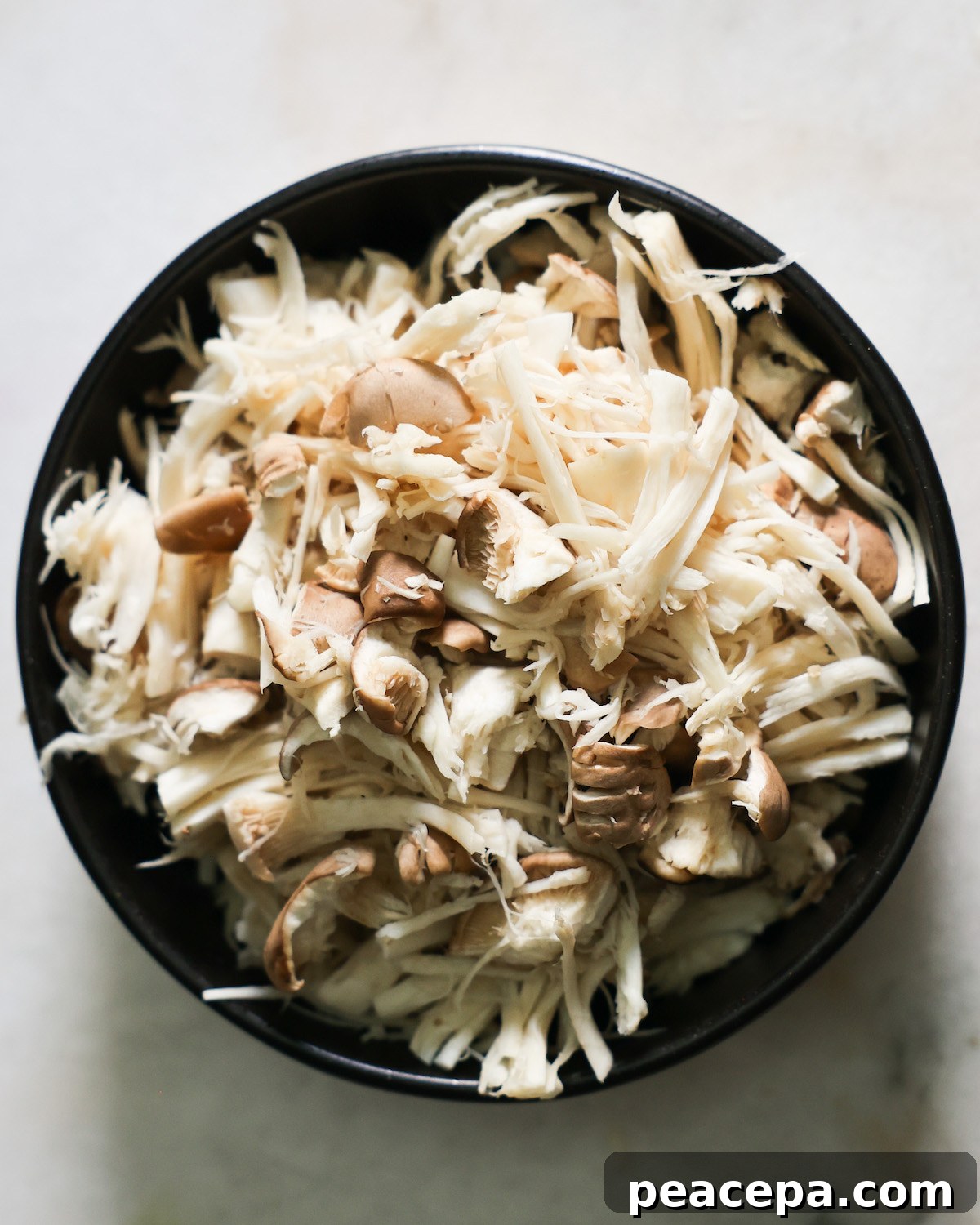 shredded king oyster mushrooms in a bowl