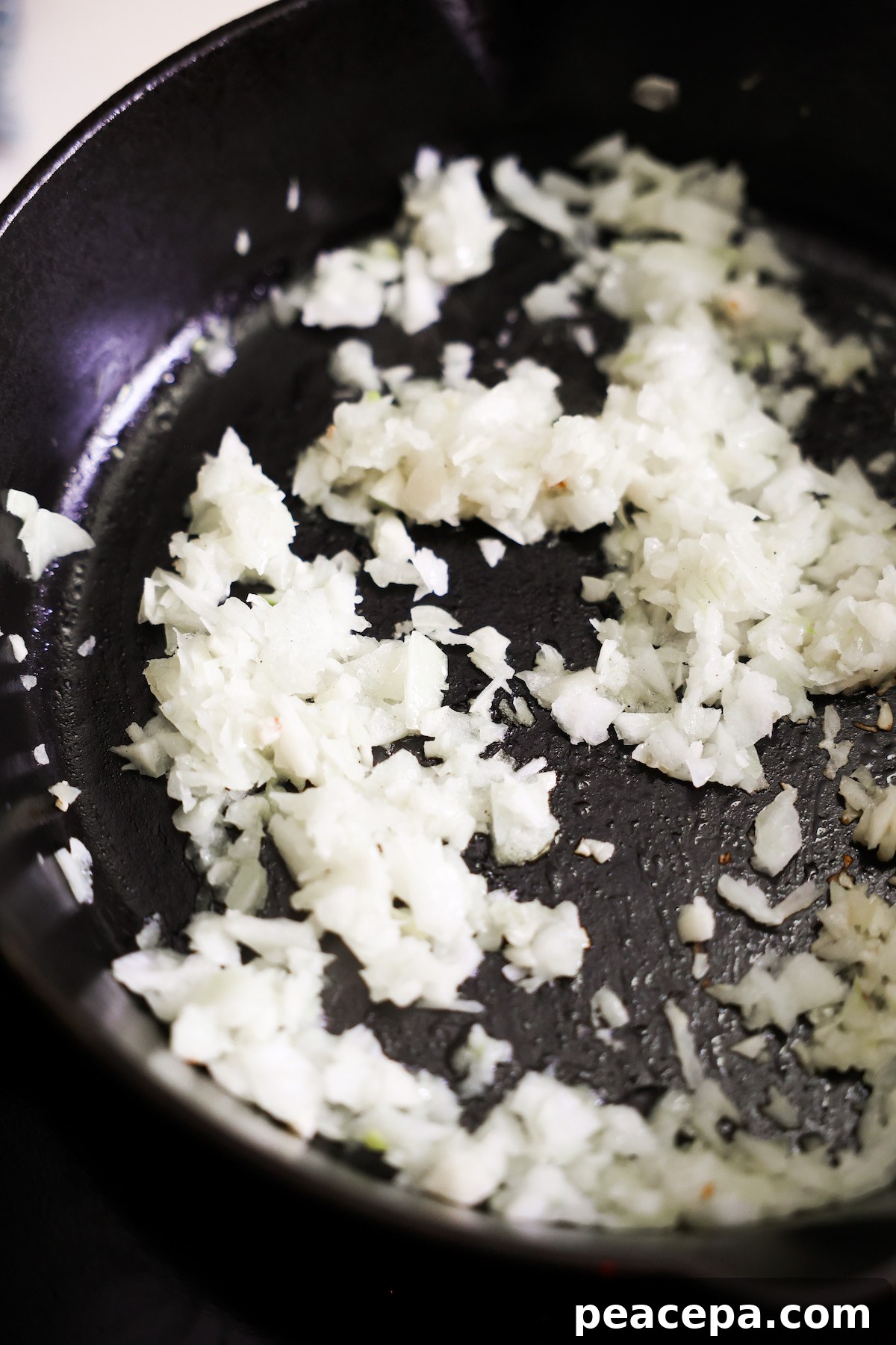 onions sautéing in a cast iron skillet