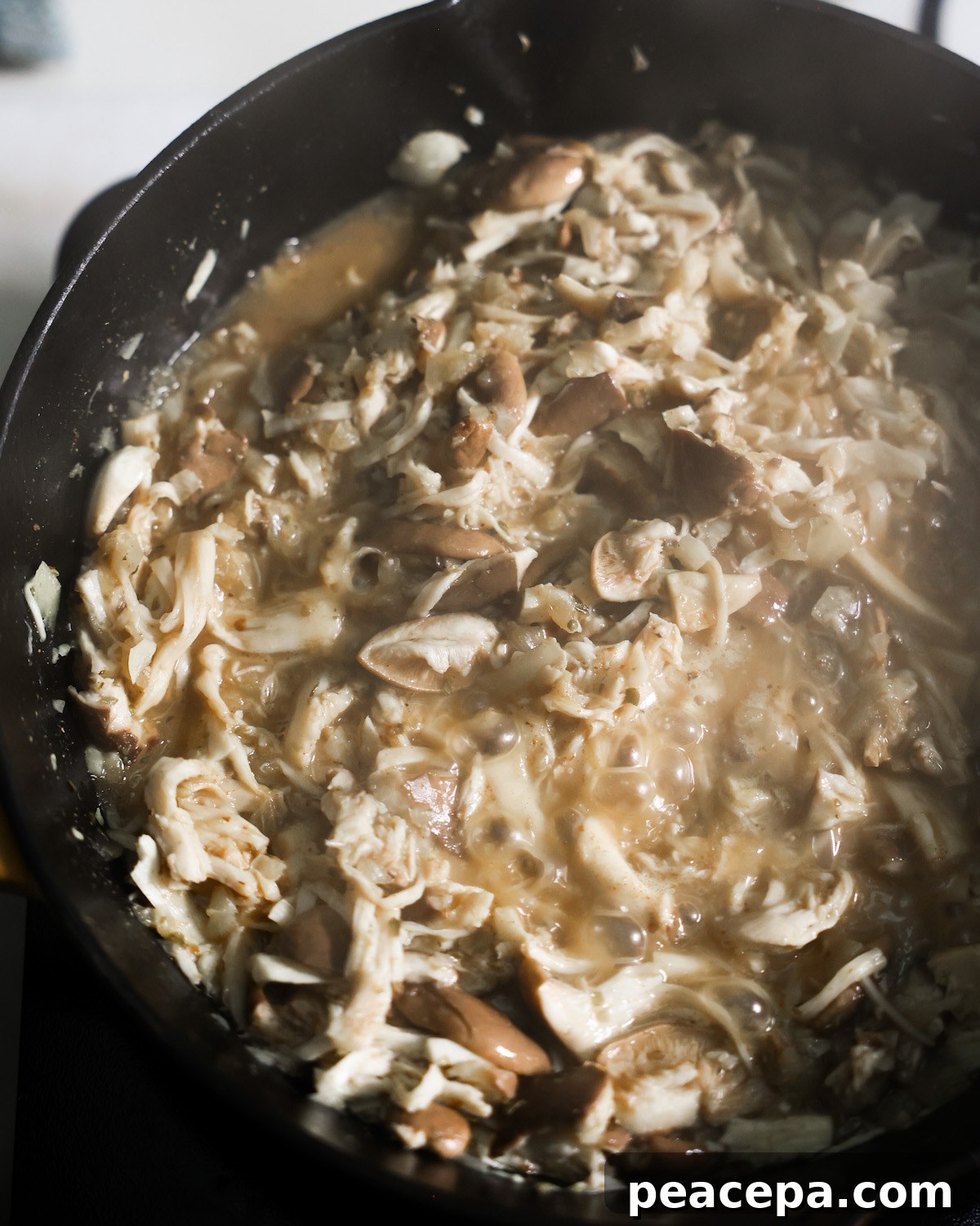 mushroom carnitas cooking in a cast iron skillet