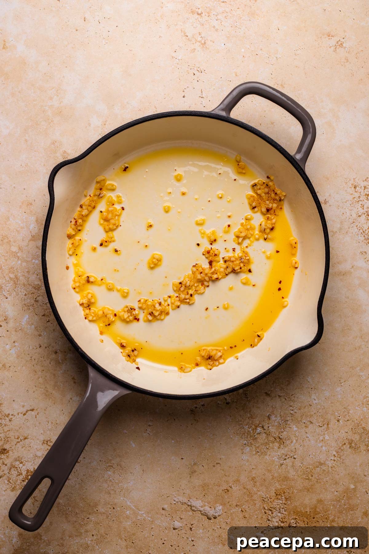 Sauteed garlic and red pepper flakes in a skillet with olive oil.