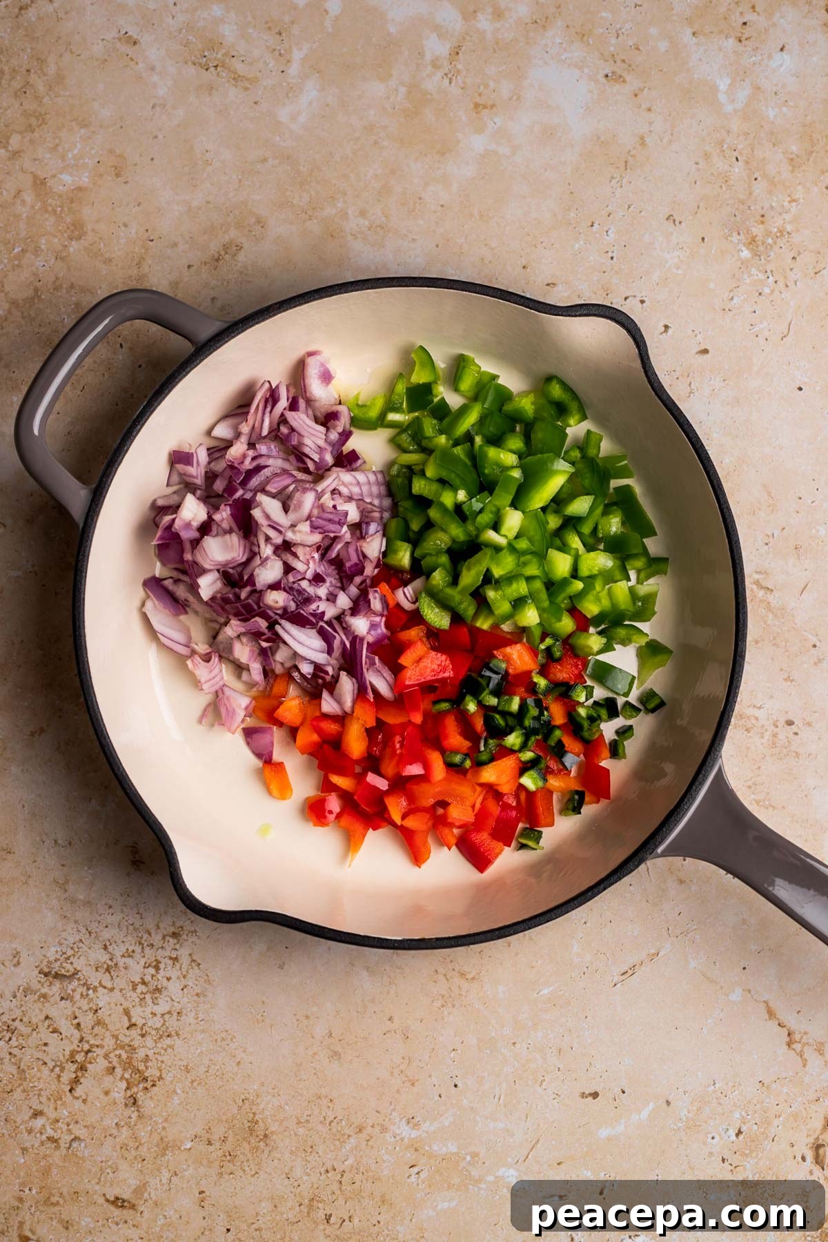 overhead of aromatics sautéing in a skillet