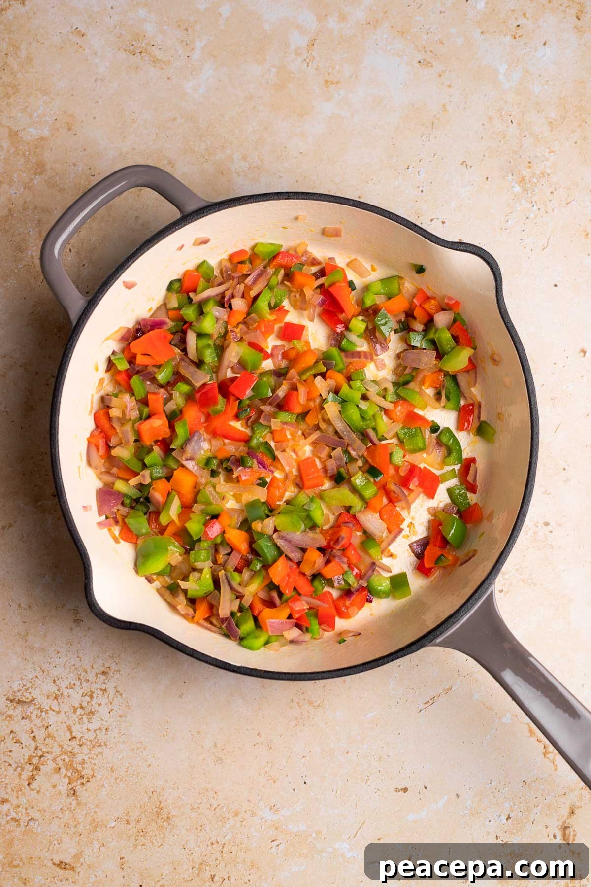 overhead of veggies sauteed in a grey skillet