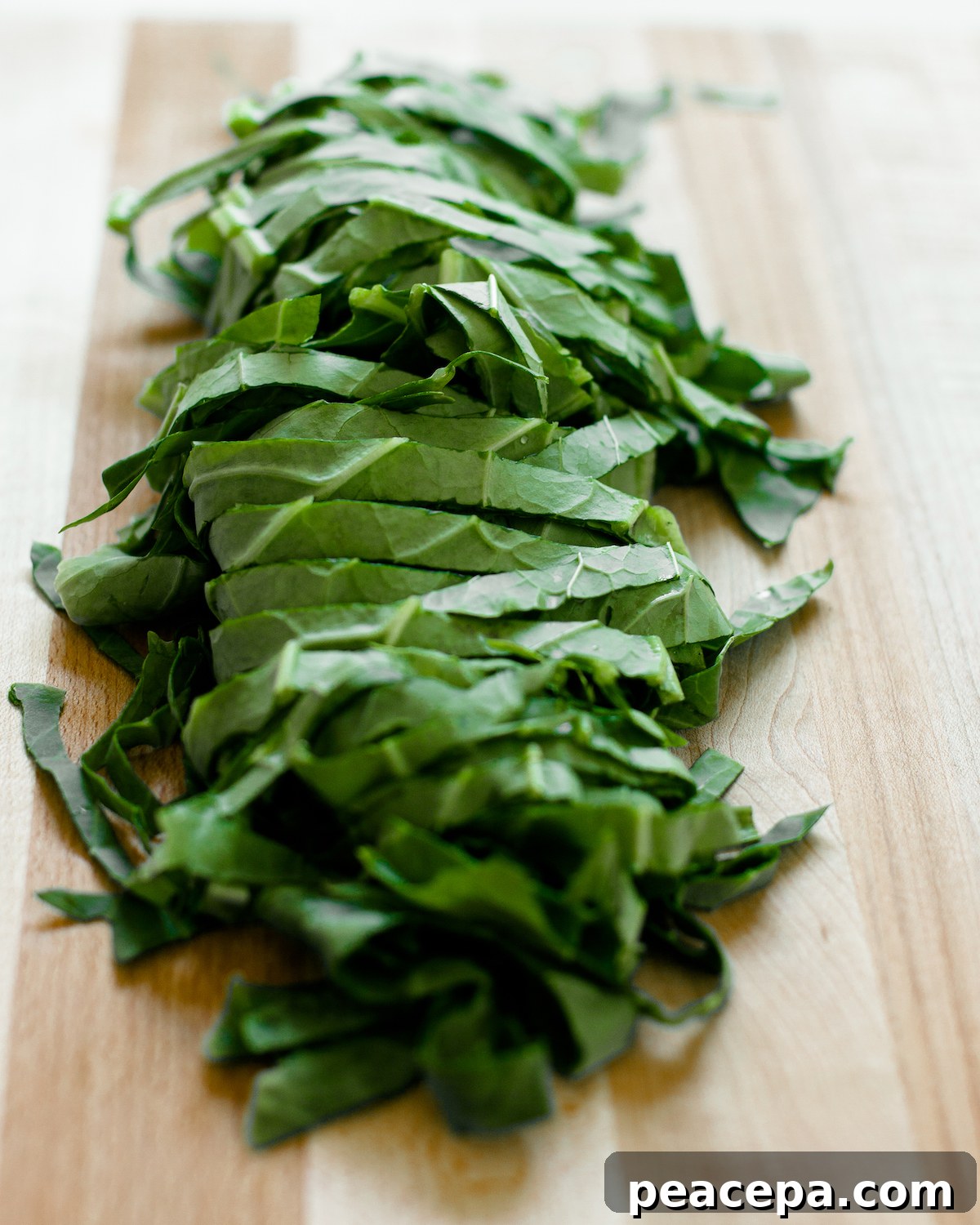 Chopped collard greens on a wooden cutting board.