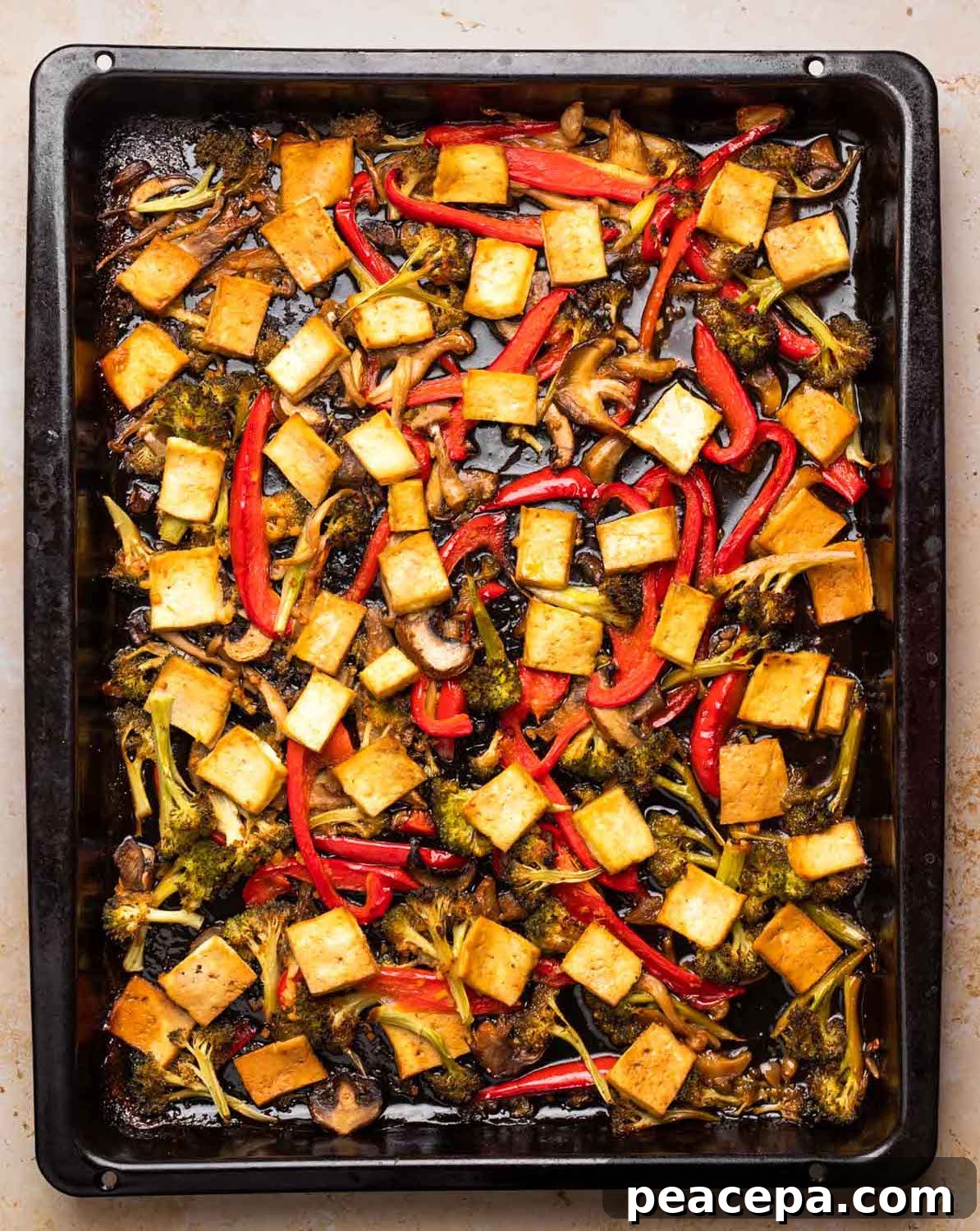Roasted maple teriyaki tofu and veggies on a baking sheet.