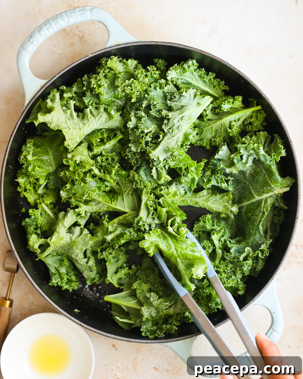 overhead tossing kale with spices