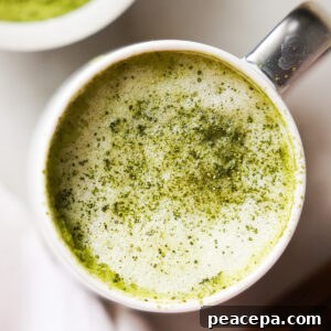 A close-up overhead shot of a oat milk matcha latte sprinkled with matcha.