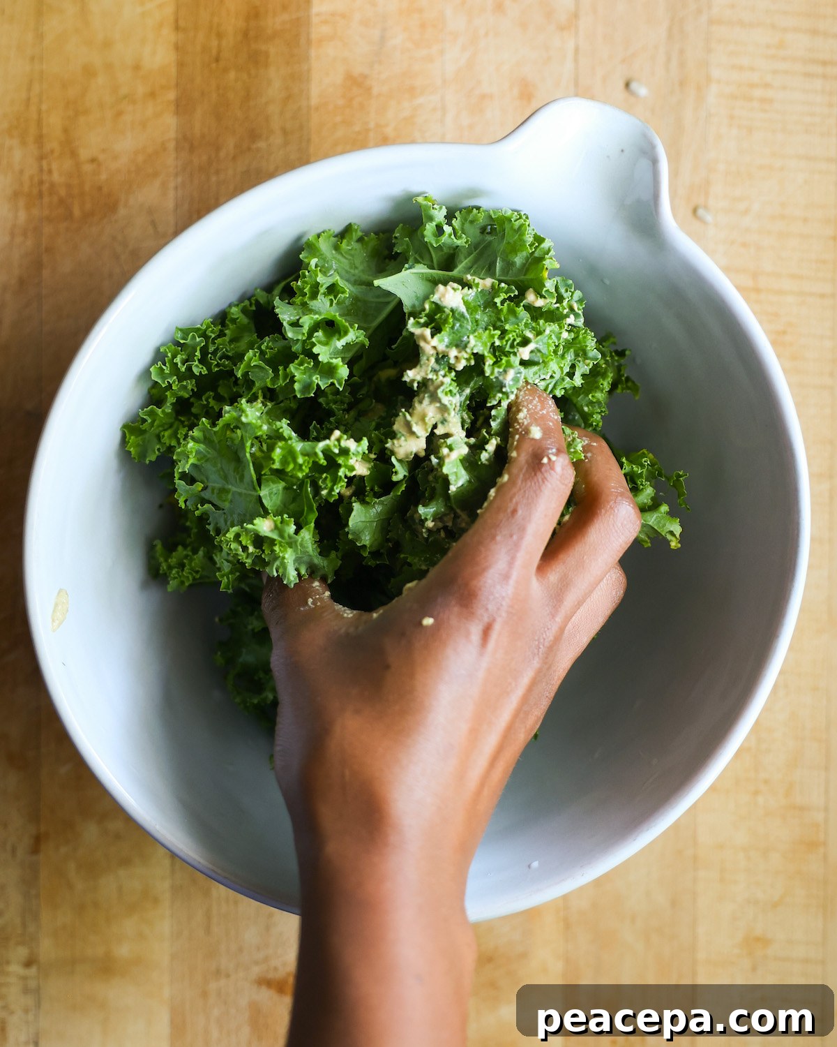 brown hand massaging kale