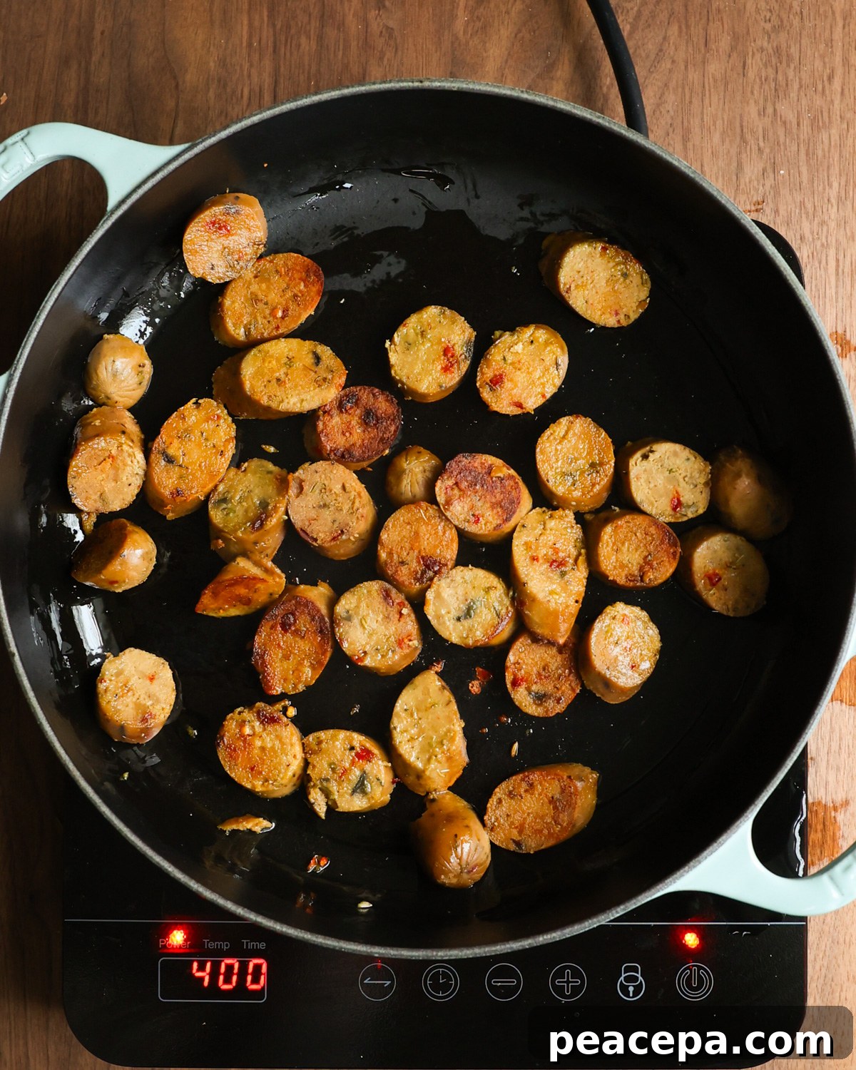 overhead of sausages browning in pan