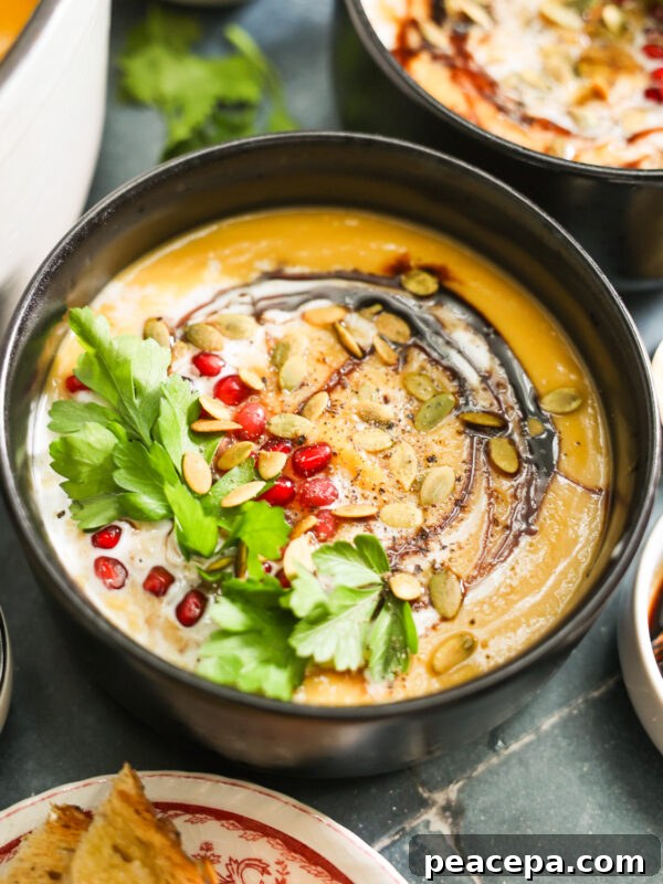 Vegan Butternut Squash Soup topped with coconut milk and pomegranates