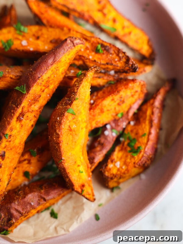 close up of sweet potato wedges on a pink plate