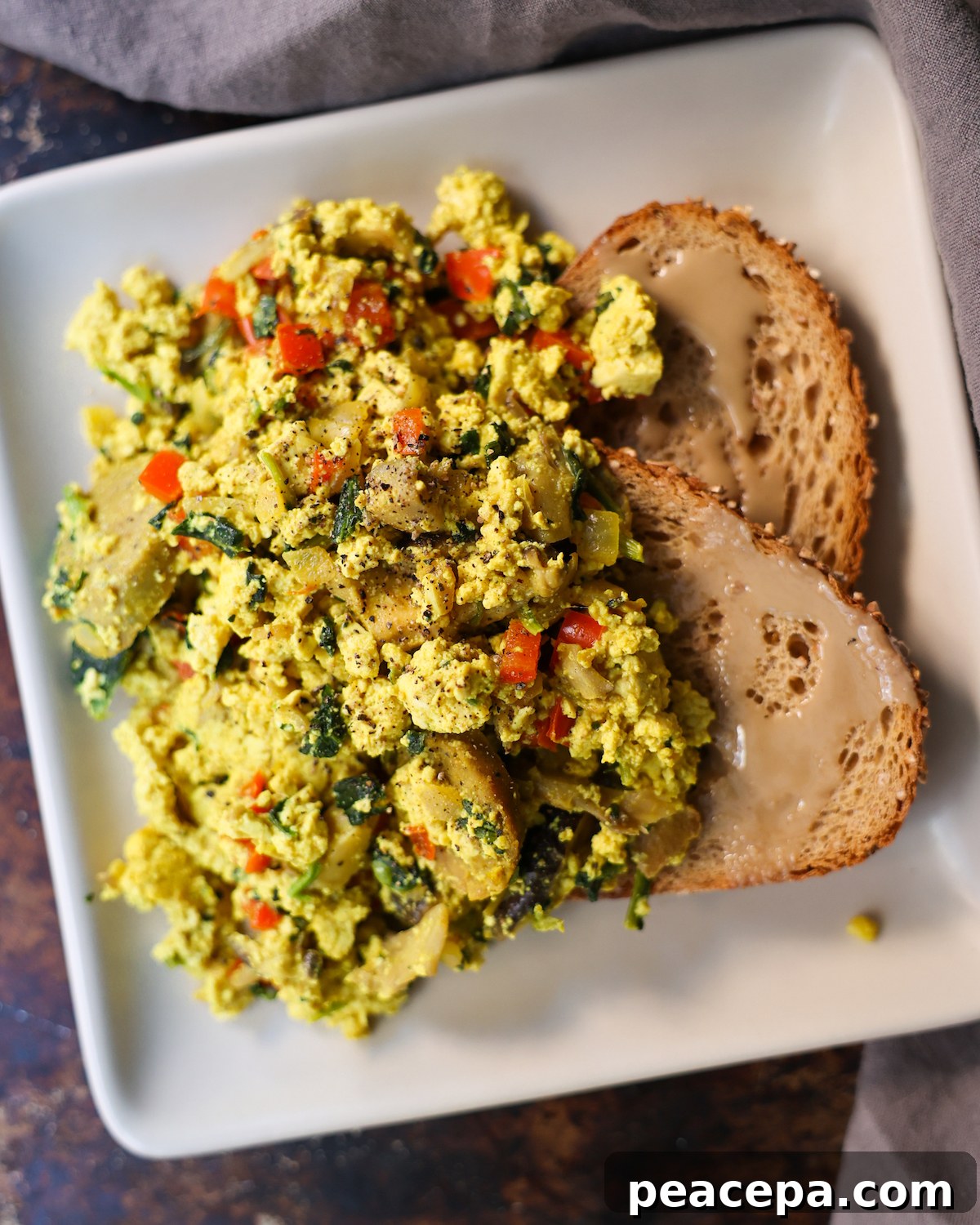 overhead of tofu scramble on a white plate with toast