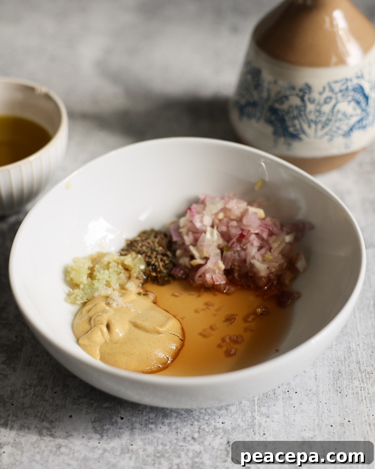 ingredients for nicoise dressing in a white bowl