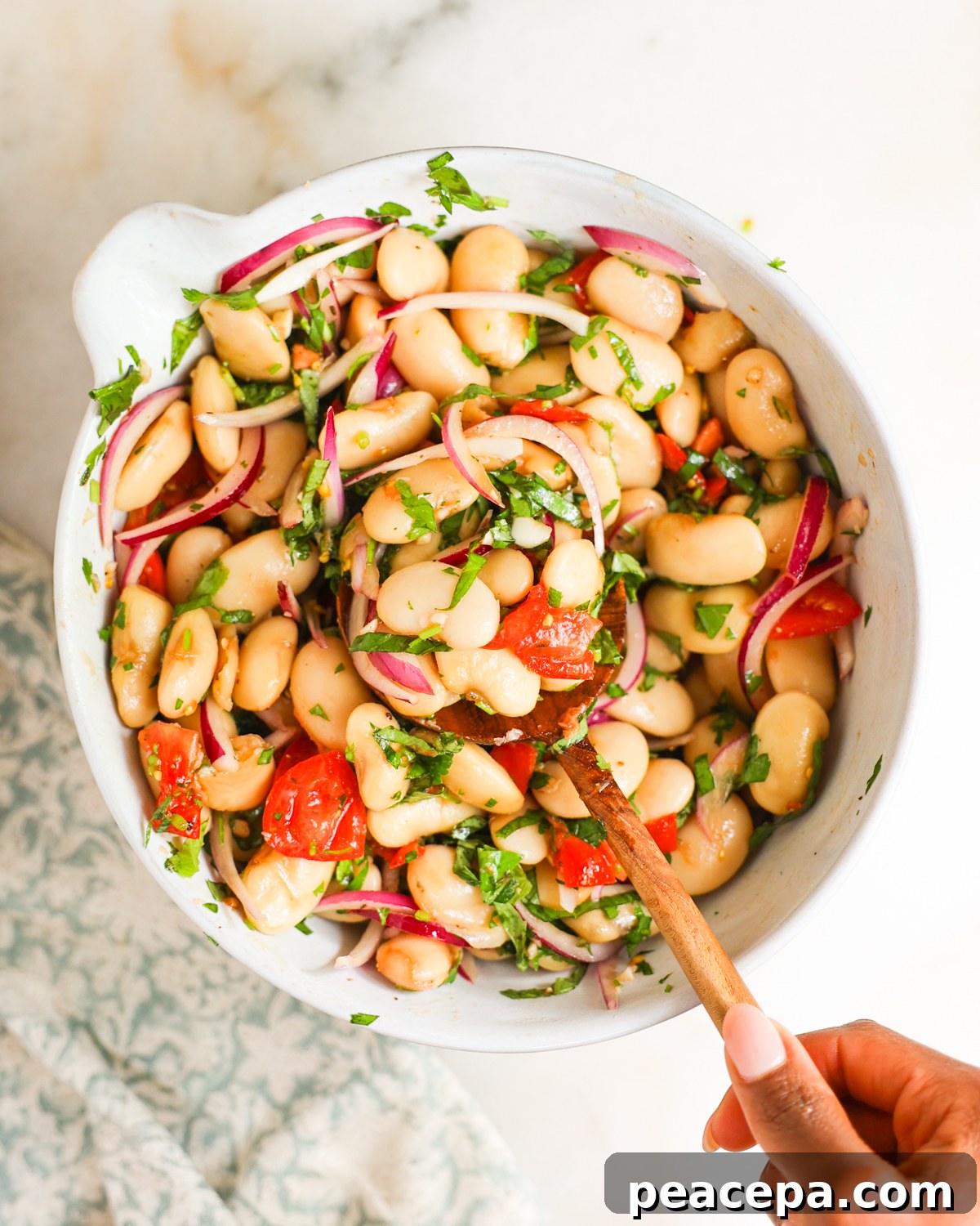 tossed white bean salad in mixing bowl