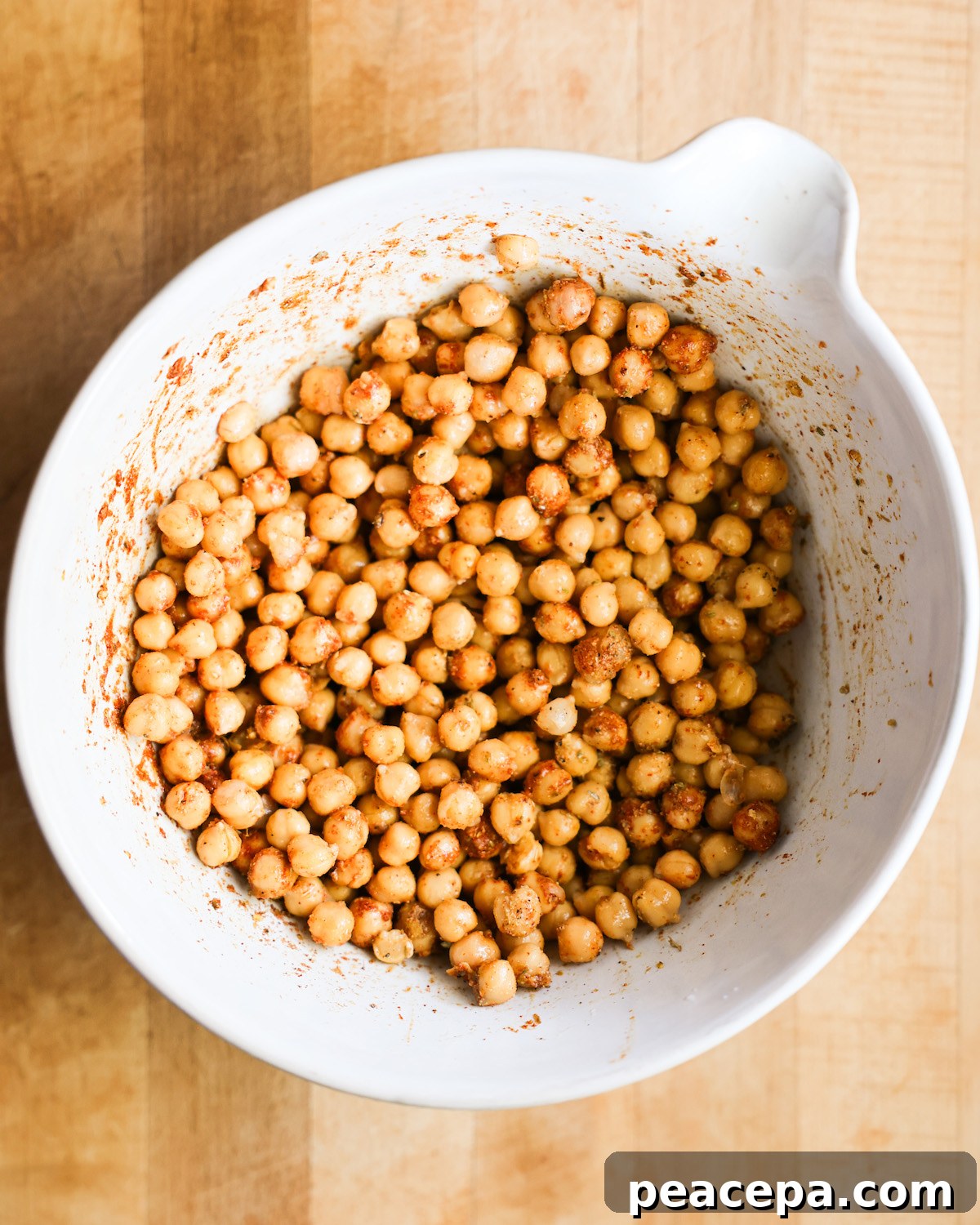 A bowl of seasoned chickpeas before roasting.