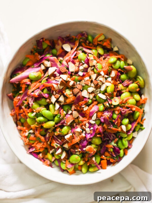 An overhead shot of a bowl of edamame salad garnished with chopped almonds.