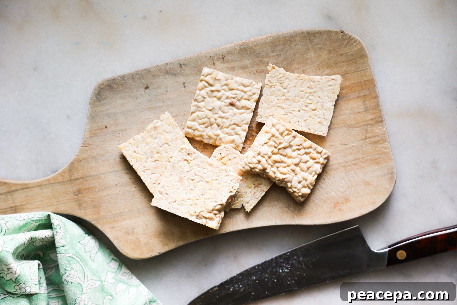 Sliced tempeh on cutting board.