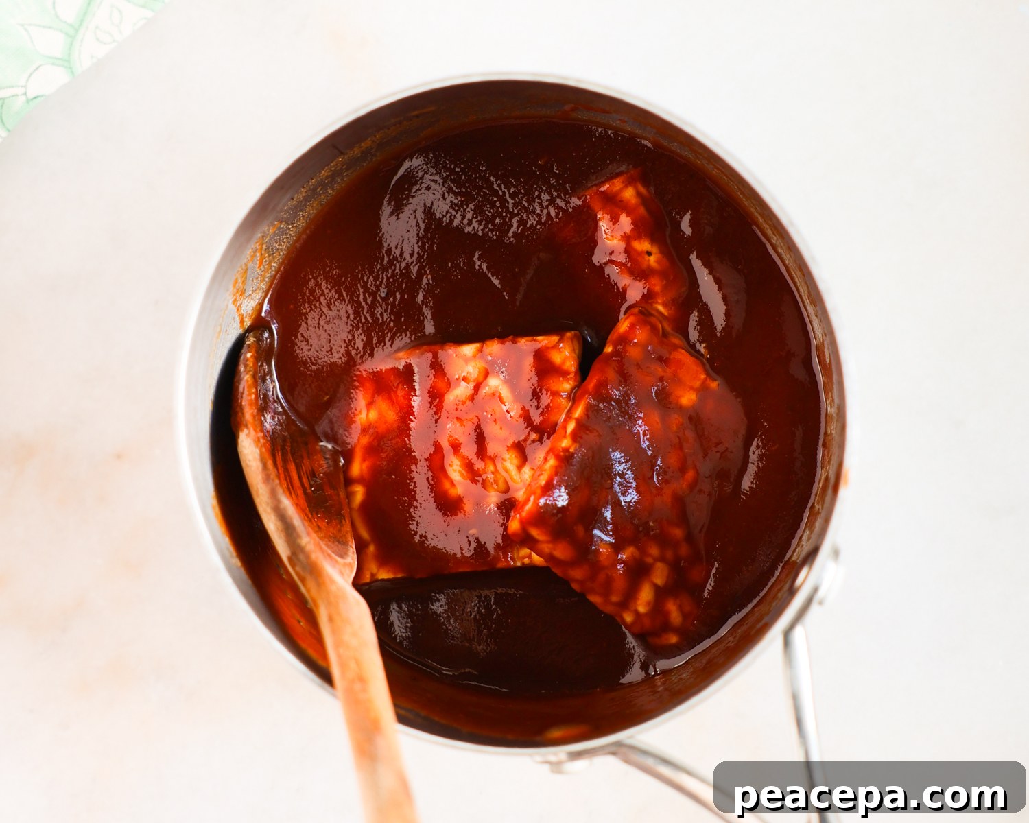 Stirring tempeh in BBQ sauce.